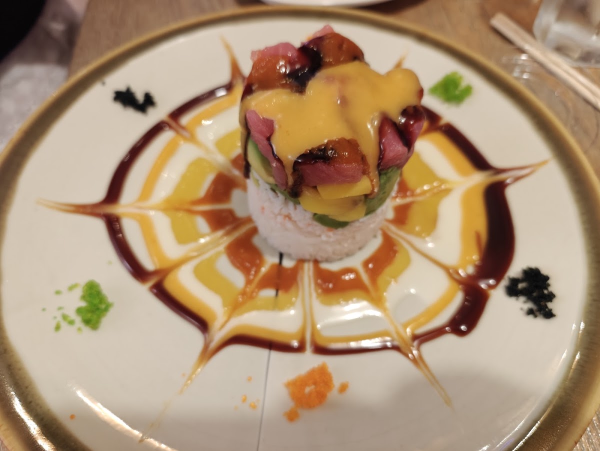 An artfully plated sushi tower with a decorative sauce design at Ozeki
